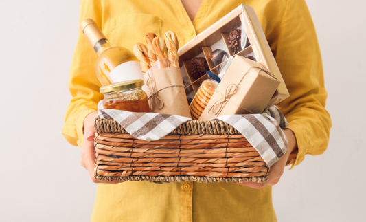 woman holding gift basket with wine, breads, and cookies