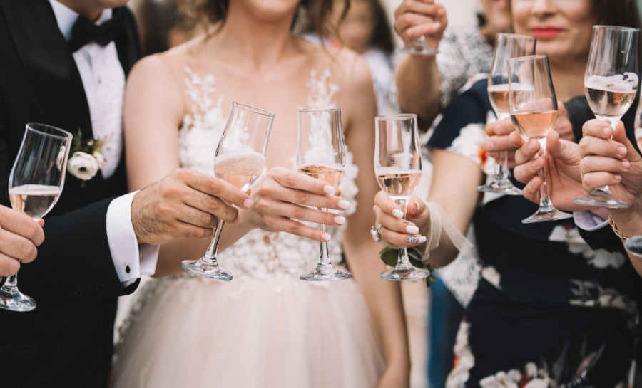 bride, groom, and guests cheersing bubbly