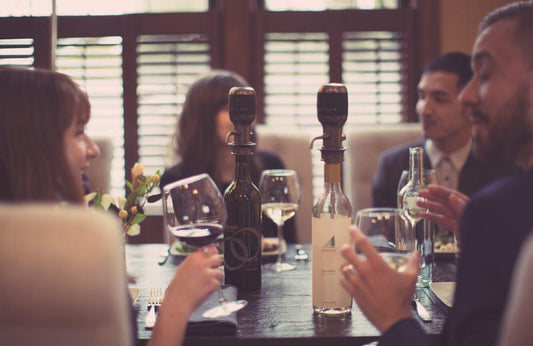 People at a dinner party drinking wine with the Aervana Original Wine Aerator
